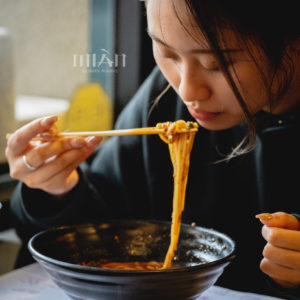 Girl eating Mian noodles